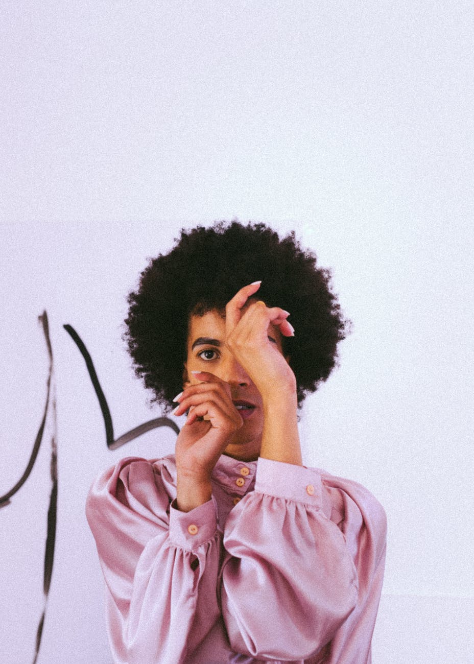 trendy young ethnic man twisting hands in front of face